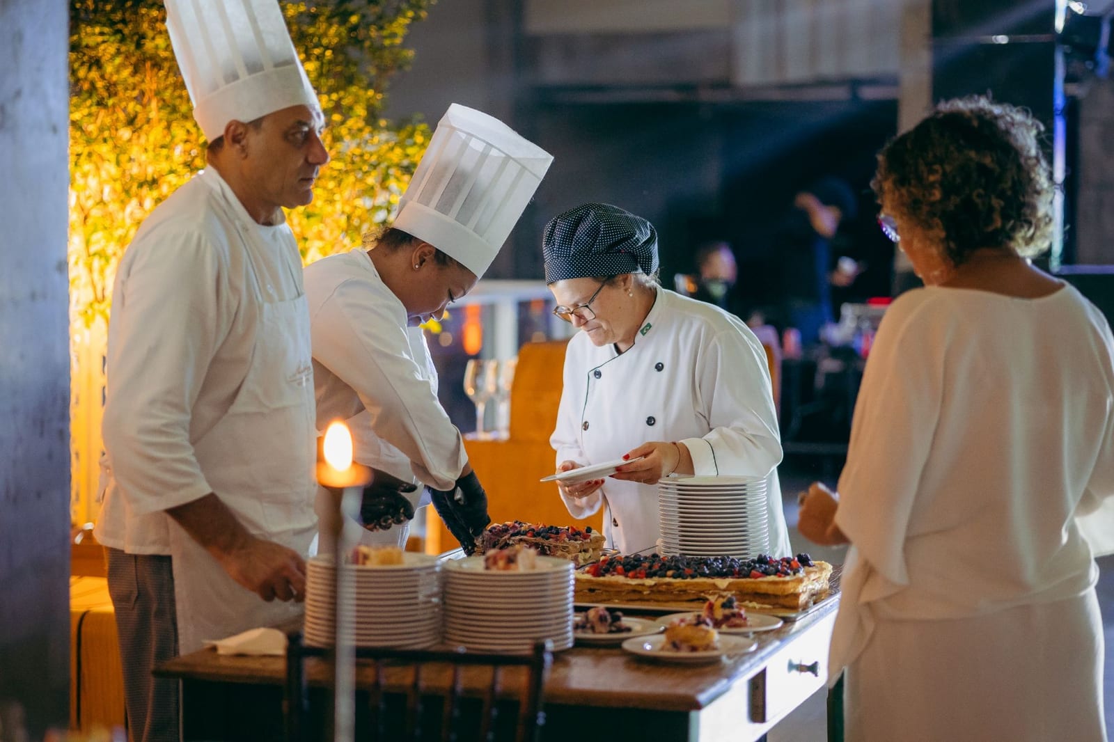Equipe de cozinha serve mil-folhas com frutas vermelhas