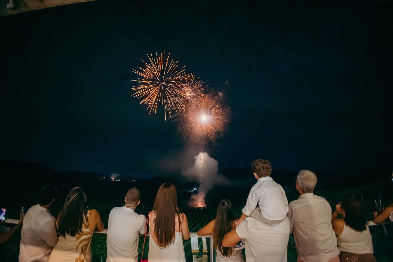 Convidados de branco assistem aos fogos da virada sobre os vinhedos